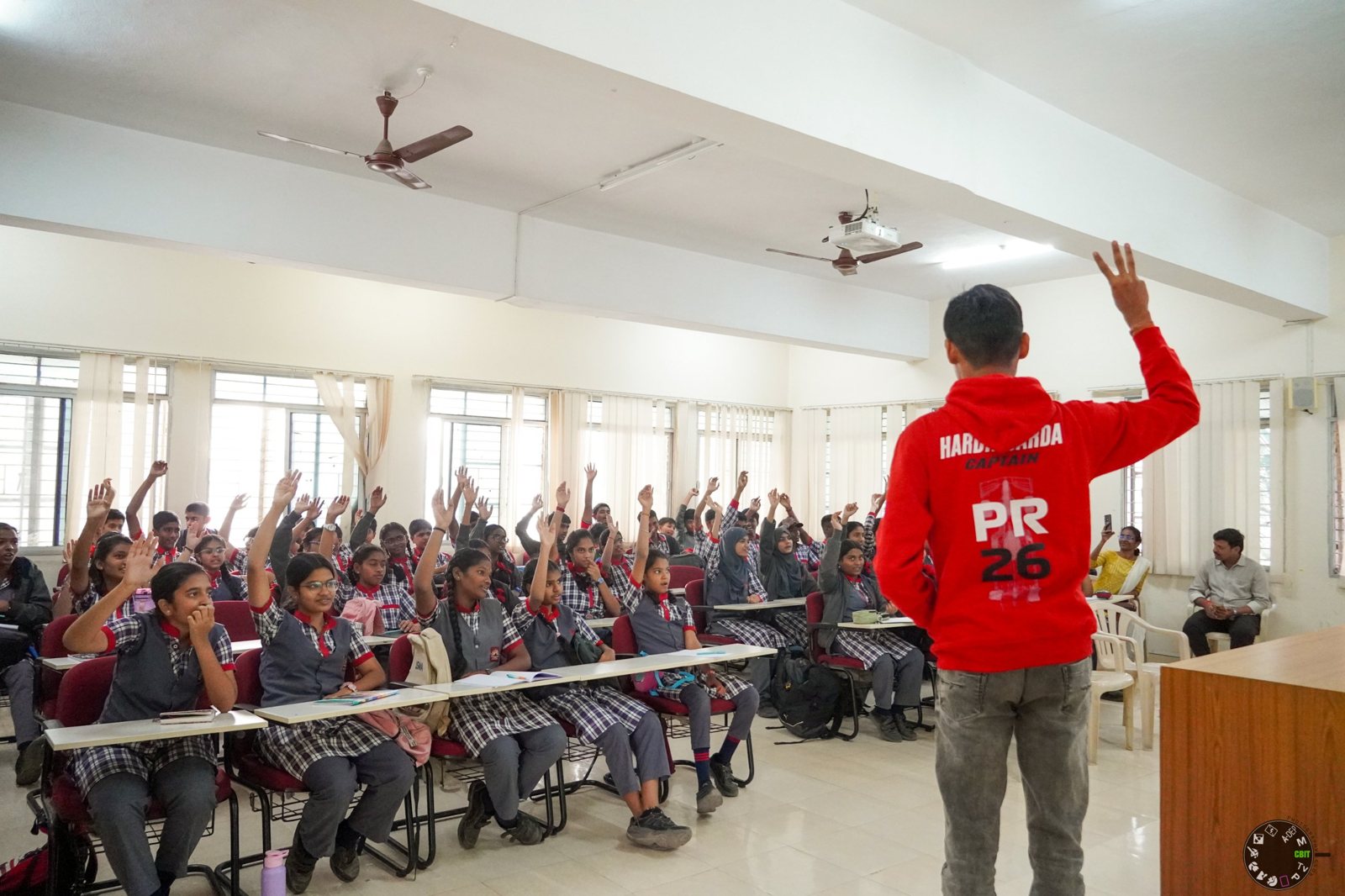 Hardik Sarda, in his captain's hoodie, taking a session with school students